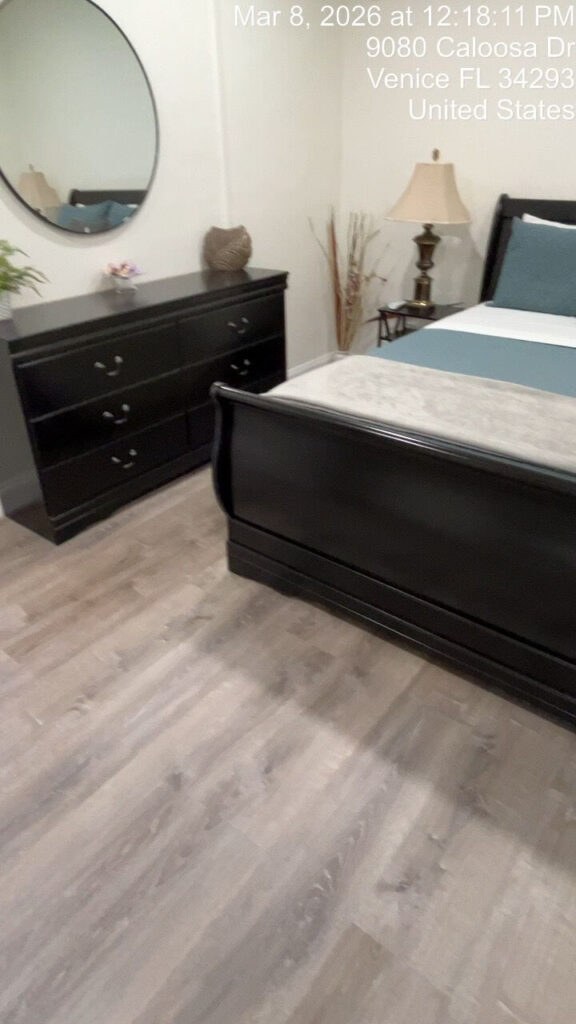 Made bed with a folded towel bow in a cleaned rental