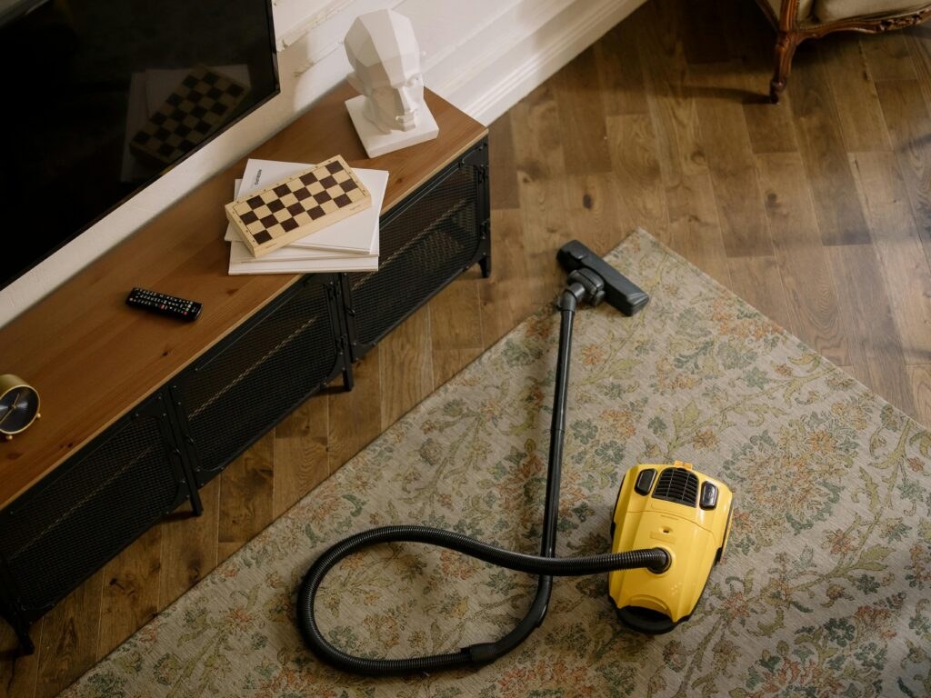 Yellow vacuum cleaner on a freshly cleaned rug