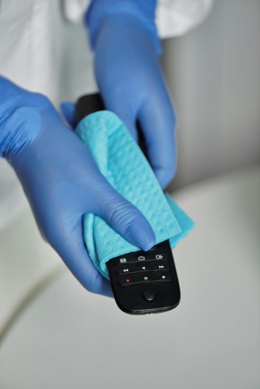 Gloved hand wiping a bathroom sink during a turnover clean